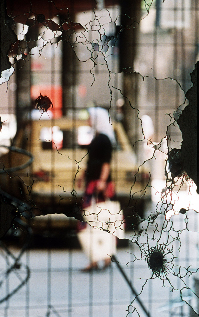 A bullet-shattered mirror in the centre of Sarejevo reflects a street scene in the summer of 1992.